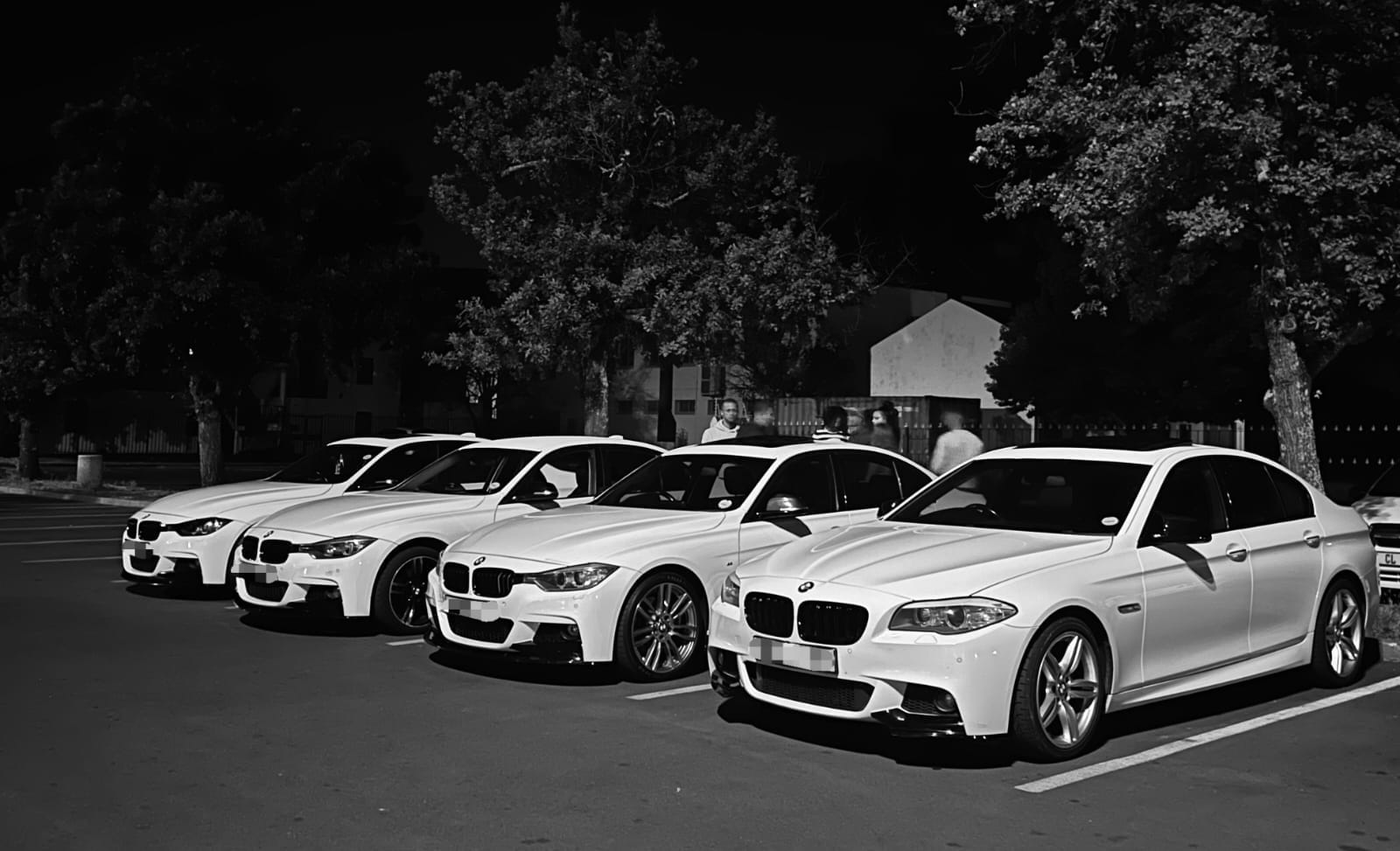 The Deluxe Travel Tours BMW fleet photographed at night in black and white